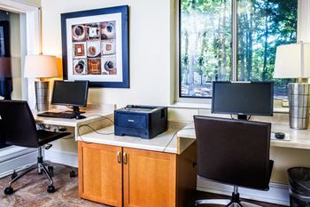 an office with a desk with two computer monitors and a window